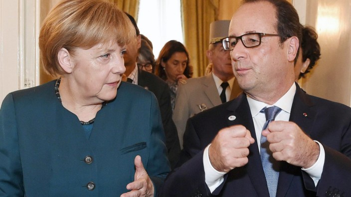 France's President Francois Hollande talks with German Chancellor Angela Merkel during a meeting on the sidelines of a Europe-Asia summit in Milan