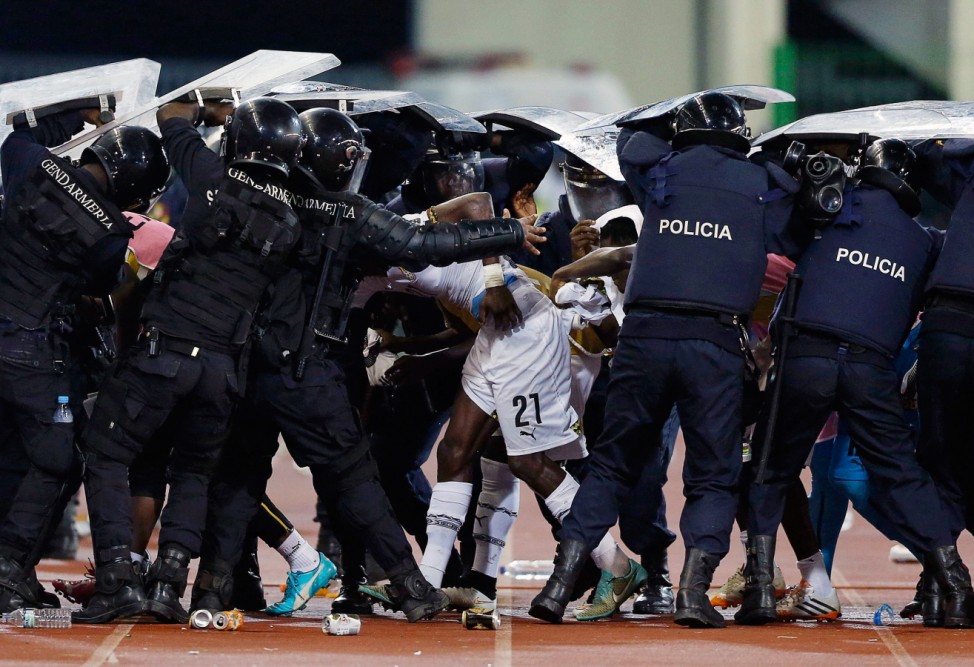 Riot police shield Ghana's John Boye and team mates from objects thrown by Equatorial Guinea fans at the end of the first half of the 2015 African Cup of Nations semi-final soccer match in Malabo