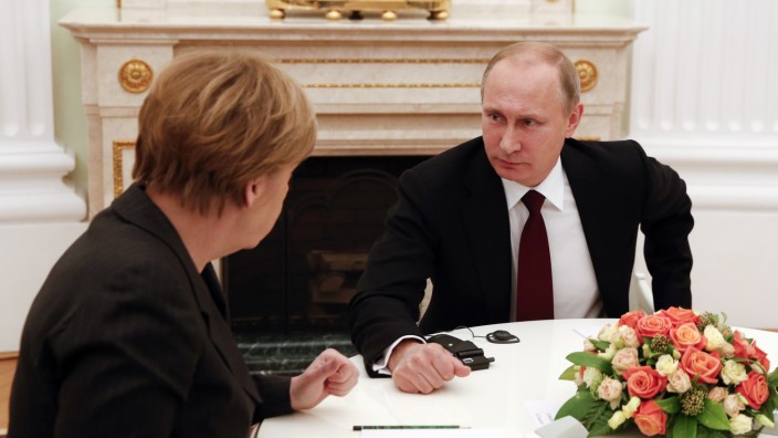 Russia's President Putin listens to German Chancellor Merkel during a meeting on resolving the Ukraine crisis at the Kremlin in Moscow
