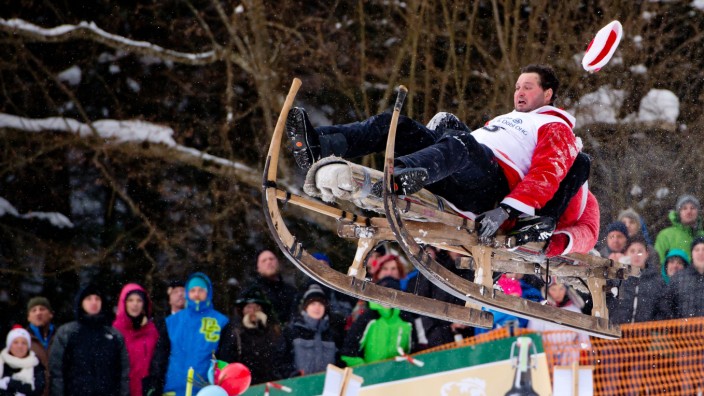 Schnablerrennen in Oberbayern: Entspannung sieht anders aus - da hilft auch das Weihnachtsmann-Kostüm nichts: Zwei Männer fliegen beim Schnablerrennen durch die Luft.