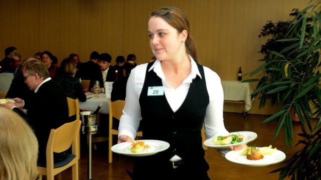 Ausbildung: Trotz Prüfungssituation gelingt es Bianca Baumann souverän, drei beladene Teller gleichzeitig zwischen den Tischen hindurch zu balancieren.