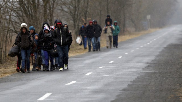 A group of Kosovars walk along a road after they crossed illegally the Hungarian-Serbian border near the village of Asotthalom