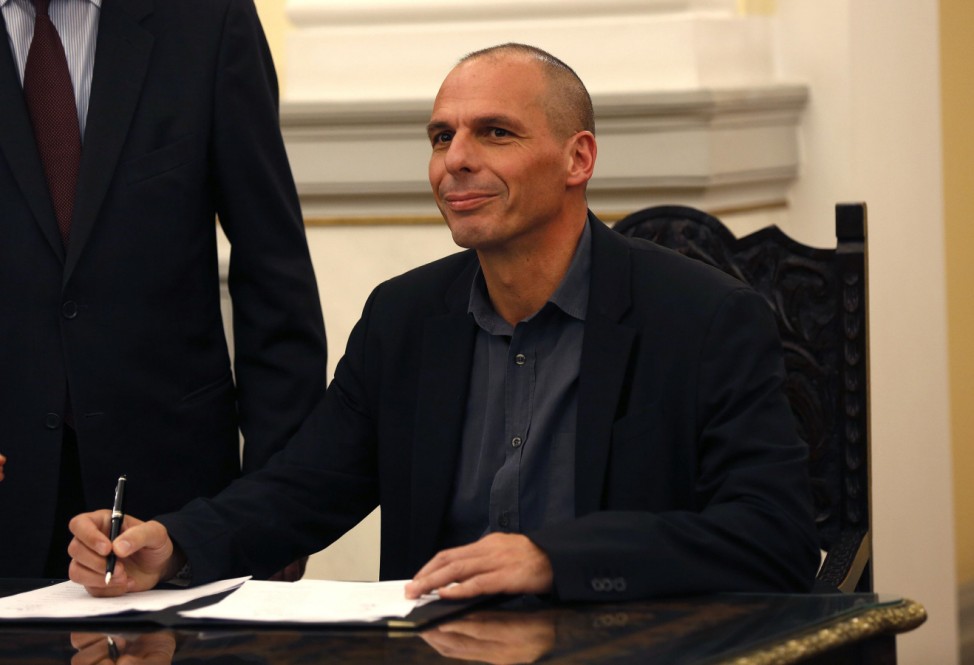 Newly appointed Greek Finance Minister Yanis Varoufakis signs official documents following a swearing in ceremony at the presidential palace in Athens