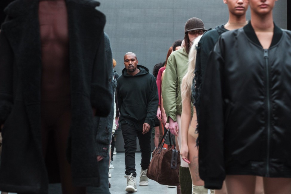 Singer Kanye West walks past models after presenting his Fall/Winter 2015 partnership line with Adidas at New York Fashion Week
