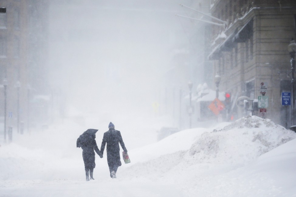 Couple walks hand-in-hand through the snow in the Back Bay during a winter blizzard in Boston