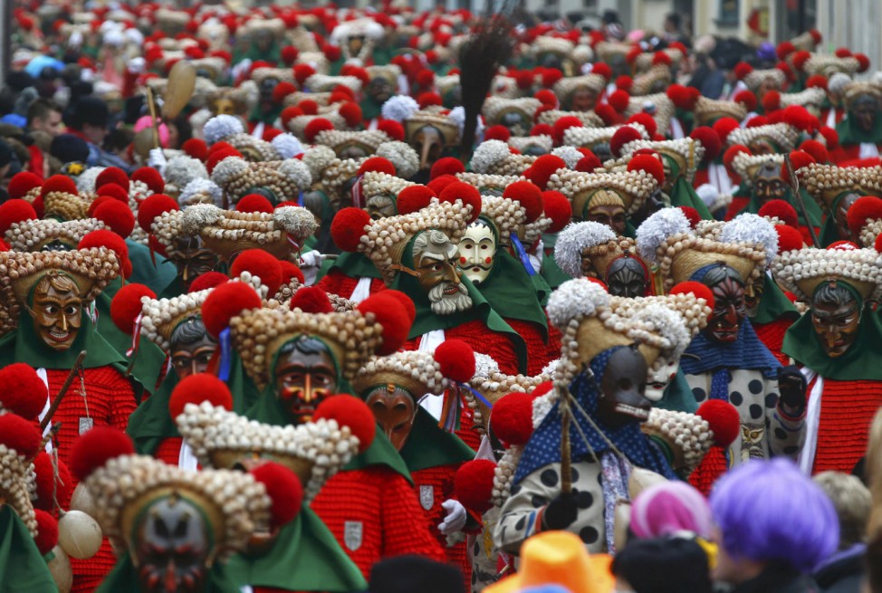 Revellers in traditional costumes and carnival masks parade through the village of Elzach in the Black Forest