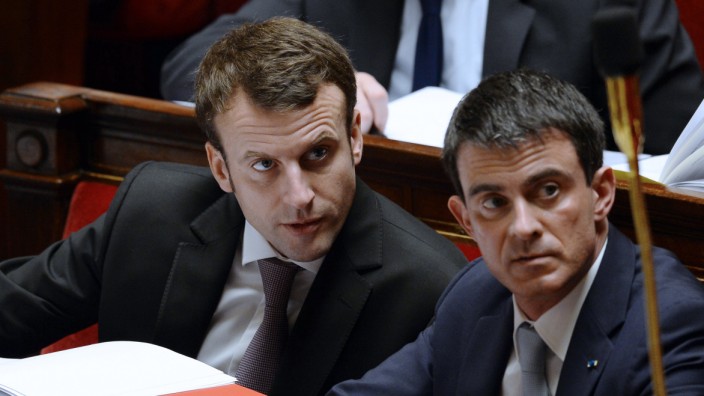 - French Economy and Industry Minister Emmanuel Macron (L) speaks with Prime minister Manuel Valls as they attend a working session on the Macron's law at the French National Assembly in Paris on Febr