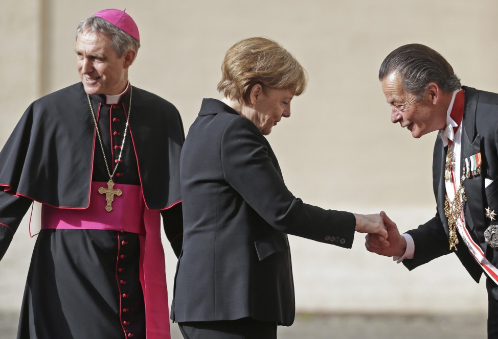 German Chancellor Merkel greets a Vatican gentleman as she arrives to meet Pope Francis at the Vatican