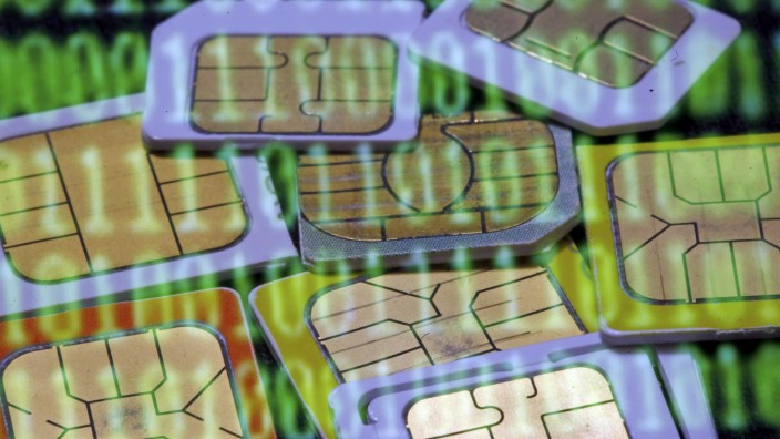 SIM cards are reflected on a monitor showing binary digits in this photo illustration taken in Sarajevo