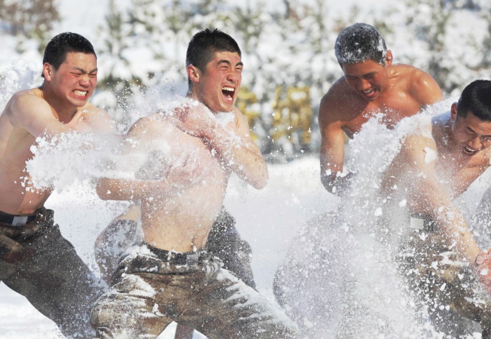 PLA soldiers throw snow onto each other as part of their winter training in temperatures below minus 10 degrees Celsius at China's border with Russia in Heihe
