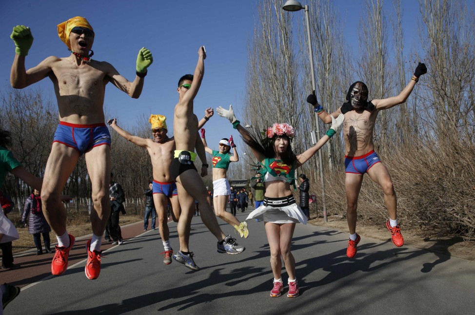 Participants jump as run in the 'Half-Naked Marathon' at a park in Beijing