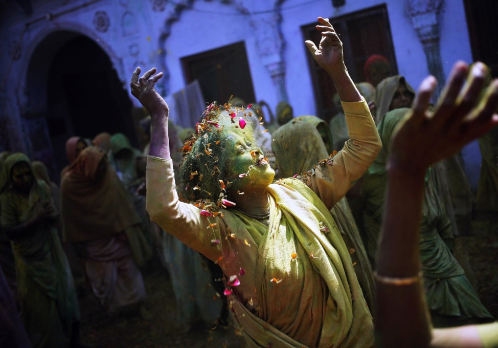 A widow daubed in colours dances in the Holi celebrations organised by non-governmental organisation Sulabh International at a widows' ashram at Vrindavan