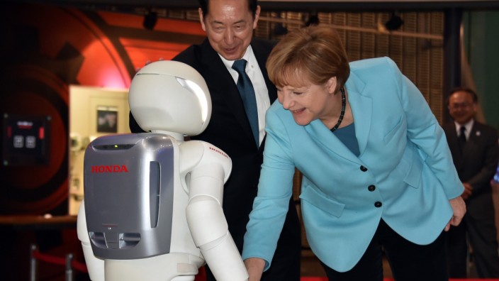 Besuch in Japan: Der kleine Roboter Asimo hüpfte und tanzte für Angela Merkel - ihren freundlichen Handschlag konnte er aber nicht entgegnen.
