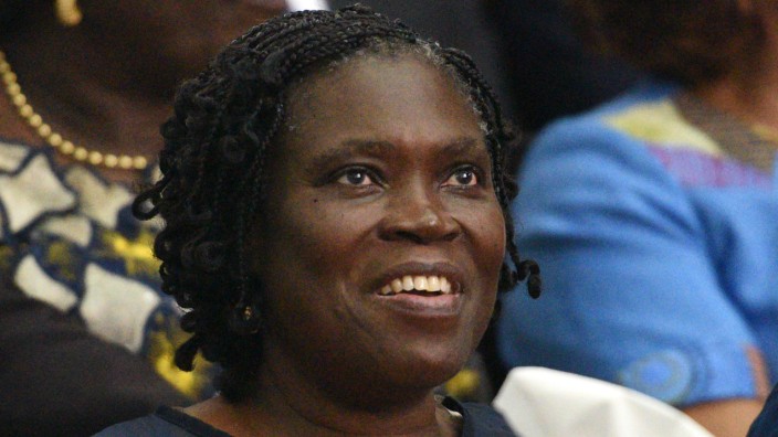 - (FILES)-Simone Gbagbo, Ivory Coast's former first lady, smiles as she sits in the dock at the Court of Justice in Abidjan on December 26, 2014 for the start of her trial. Ivory Coast's former first