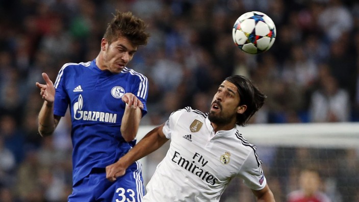 Real Madrid's Sami Khedira is challenged by Schalke 04's Roman Neustadter during their round of 16 second leg soccer match in Madrid