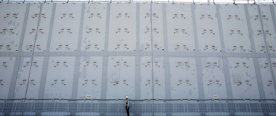 File photo shows a worker standing in front of a tsunami defence wall at Chubu Electric Power Co.'s Hamaoka Nuclear Power Station in Omaezaki