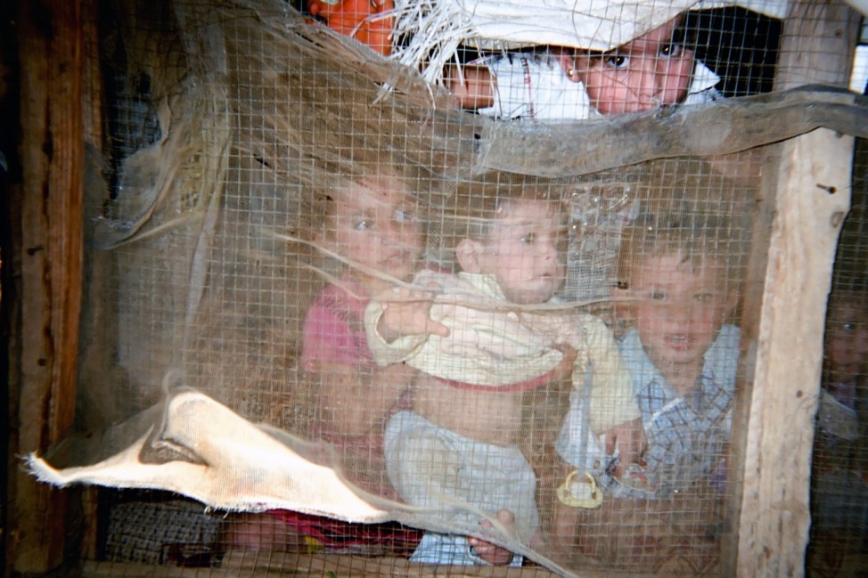 Sara, 9 years, lives in an informal settlement in Bekaa Valley. Sara photographed four children staring at her through the net of their makeshift shelter. Sara is one of the 500 children who participated in Lahza2 project. She is one of 500 children parti