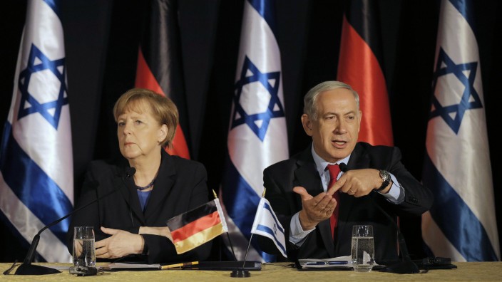 Israel's Prime Minister Netanyahu sits next to German Chancellor Merkel during their joint news conference in Jerusalem