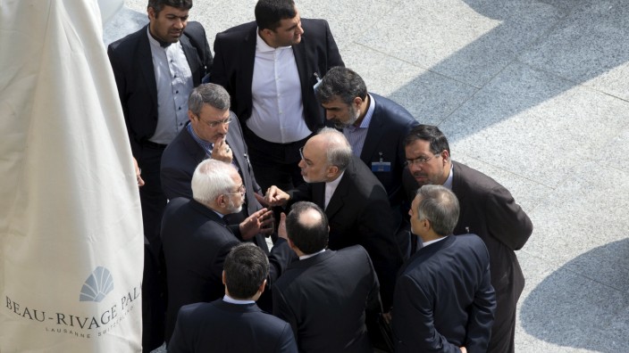 Iran's Foreign Minister Zarif and head of the Atomic Energy Organization of Iran Salehi talk outside with aides after a morning negotiation session with U.S. Secretary of State Kerry in Lausanne