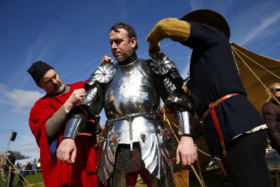 A reenactor is helped into his armour at the site of the Battle of Bosworth ahead of the arrival of Richard III's reburial procession, near Leicester, central England