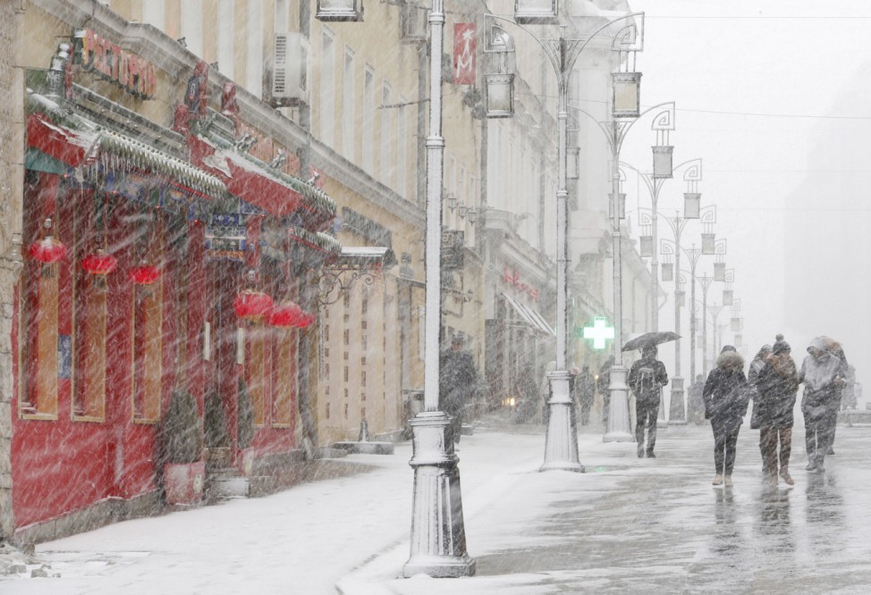 People walk during a heavy snowfall in central Moscow