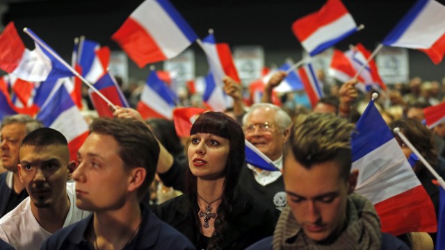 France's far-right National Front political party supporters wave French flags during a political rally with leader Marine Le Pen in Six-Fours