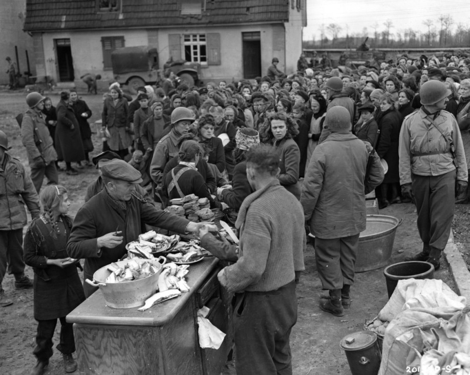 Soldaten der US-Armee geben Nahrung an Zivilisten aus, 1945