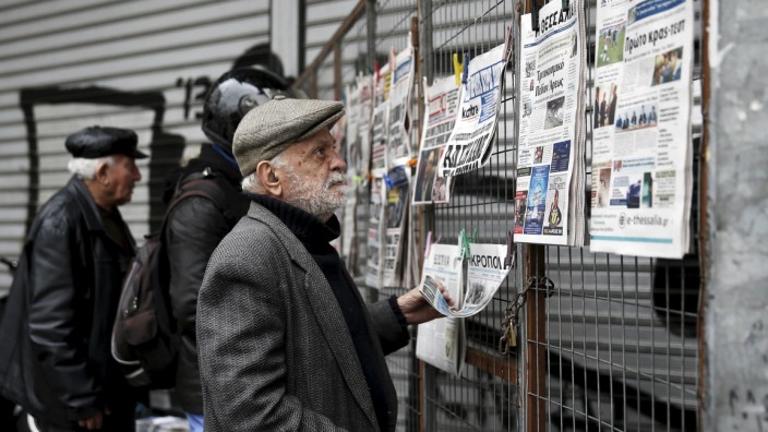 People read newspaper headlines in Athens