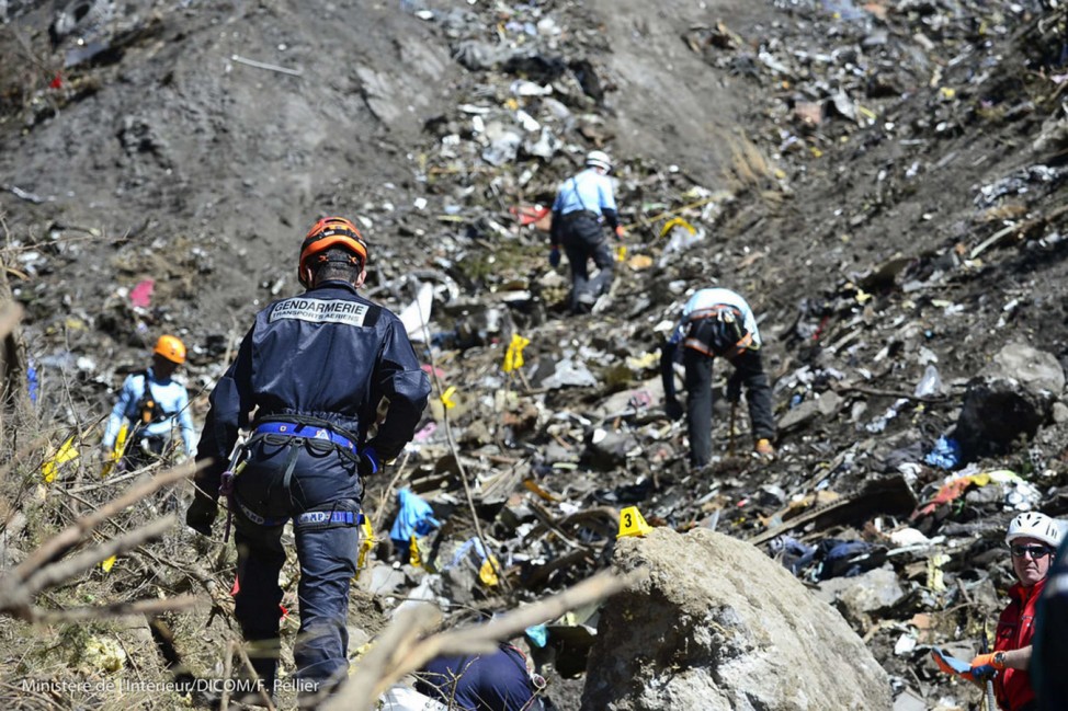 French gendarmes and investigators, seen in this picture released by the French Interior Ministry, make their way through debris from wreckage on the mountainside at the crash site of an Airbus A320, near Seyne-les-Alpes