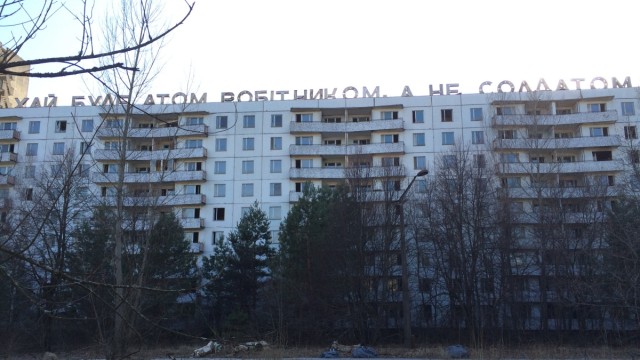 Atomruine von Tschernobyl: "Lasst das Atom regieren und nicht Soldaten", fordert der Schriftzug auf diesem verlassenen Haus in riesigen Lettern