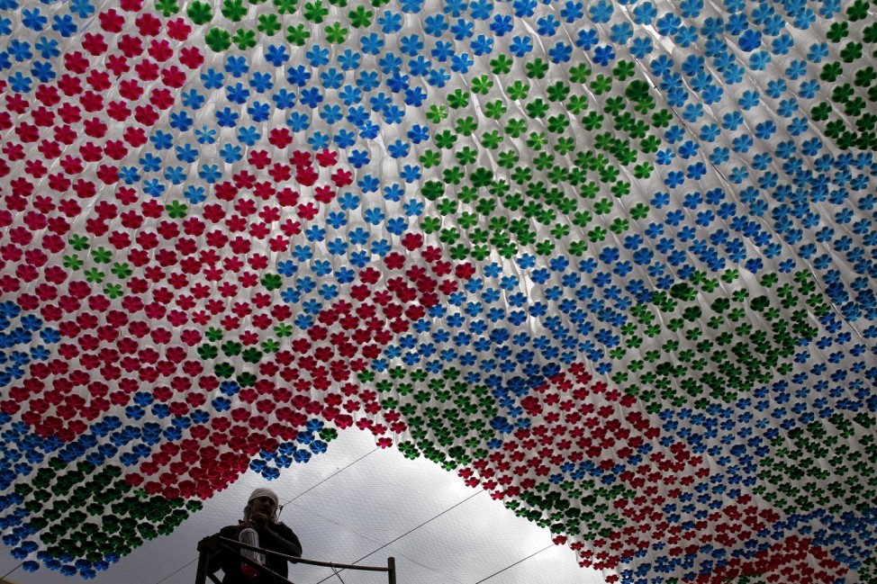 A worker stands next to an installation made of plastic bottles in Tegucigalpa