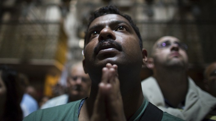 A Christian worshipper take part in a prayer after a procession in the Church of the Holy Sepulchre on Good Friday, during Holy Week in Jerusalem's Old City