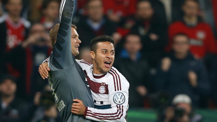 Munich's Thiago celebrates with goalkeeper Neuer after scoring the decisive penalty to defeat Bayer Leverkusen in their quarter-final German Cup (DFB-Pokal) soccer match in Leverkusen