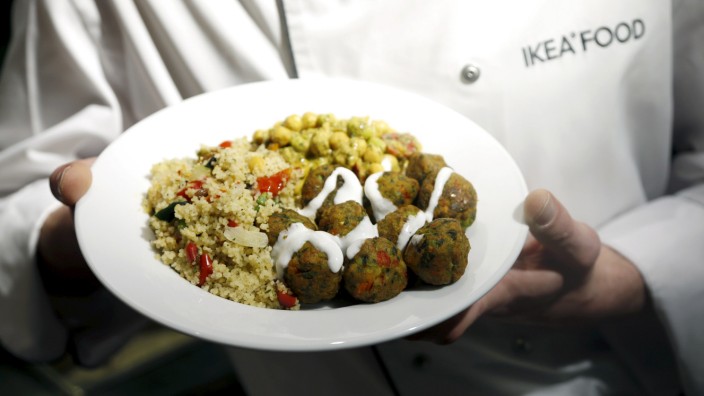 A cook displays a plate with the new 'Veggie balls' during its official launch at a IKEA store in Brussels