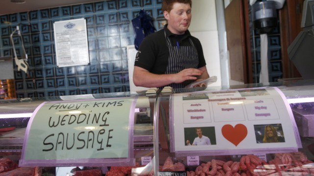 A butcher sells 'wedding sausages' next to pictures of tennis player Andy Murray and his fiancee Kim Sears in Dunblane, Scotland