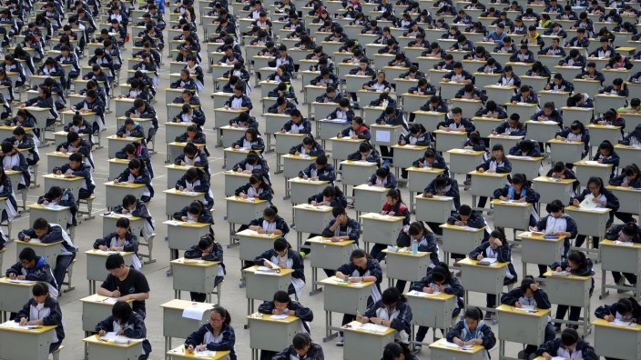 Students take an examination on an open-air playground at a high school in Yichuan