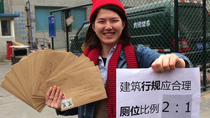 Justiz in China: Li Tingting, eine der fünf freigelassenen Frauen, posiert 2014 mit einem Poster, auf dem sie mehr Toiletten für Frauen fordert. Solche Aktionen bezeichnet der chinesische Staat als "Streitsucht und Unruhestiftung".