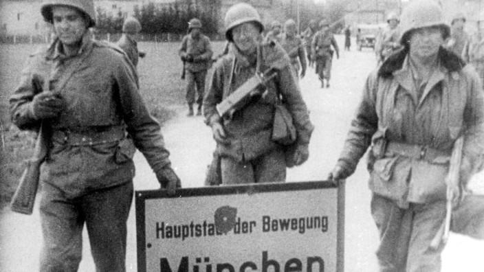 Kriegsende 1945: Amerikanische Soldaten entfernen das Ortsschild "München. Hauptstadt der Bewegung"