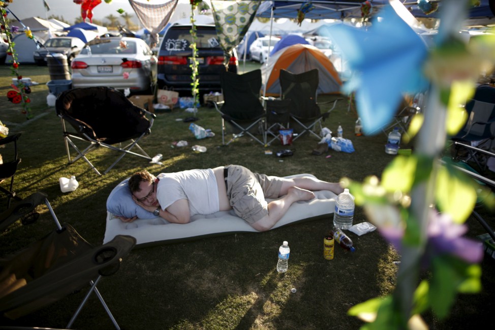 A man takes a nap in the car camping area at the Coachella Valley Music and Arts Festival in Indio