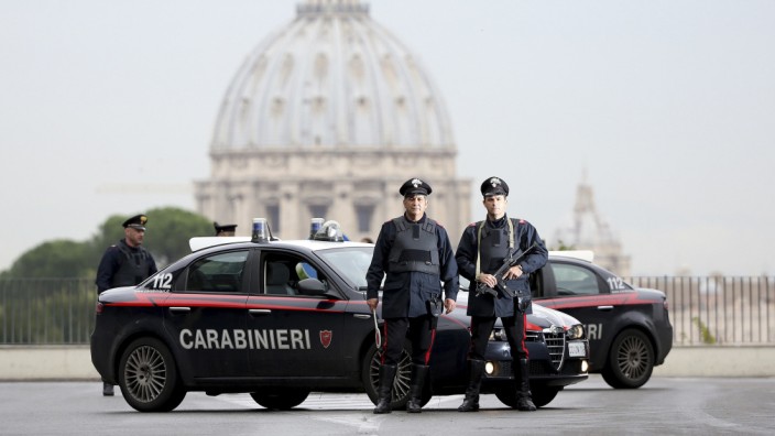 Italian Carabinieri pose in front of St. Peter's Basilica as a Carabinieri helicopter flies overhead, in Rome