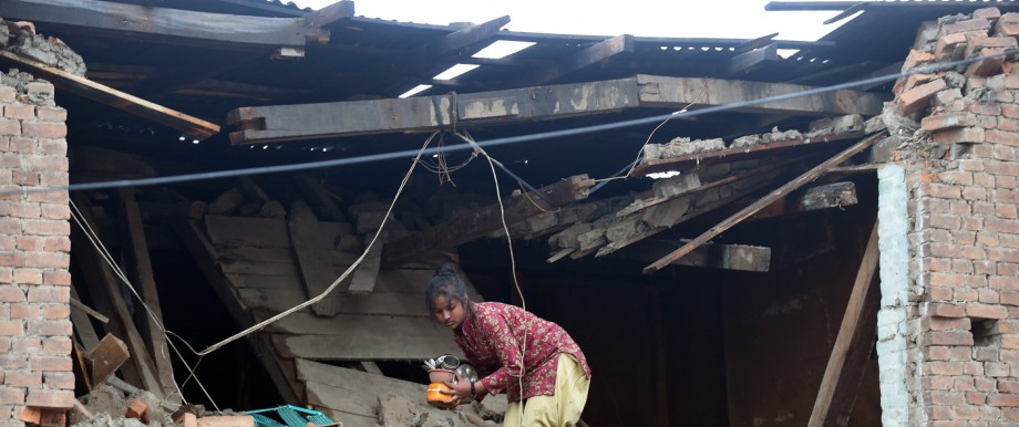 Erdbebenkatastrophe: Eine junge Nepalesin trägt Habseligkeiten aus ihrem zerstörten Haus.