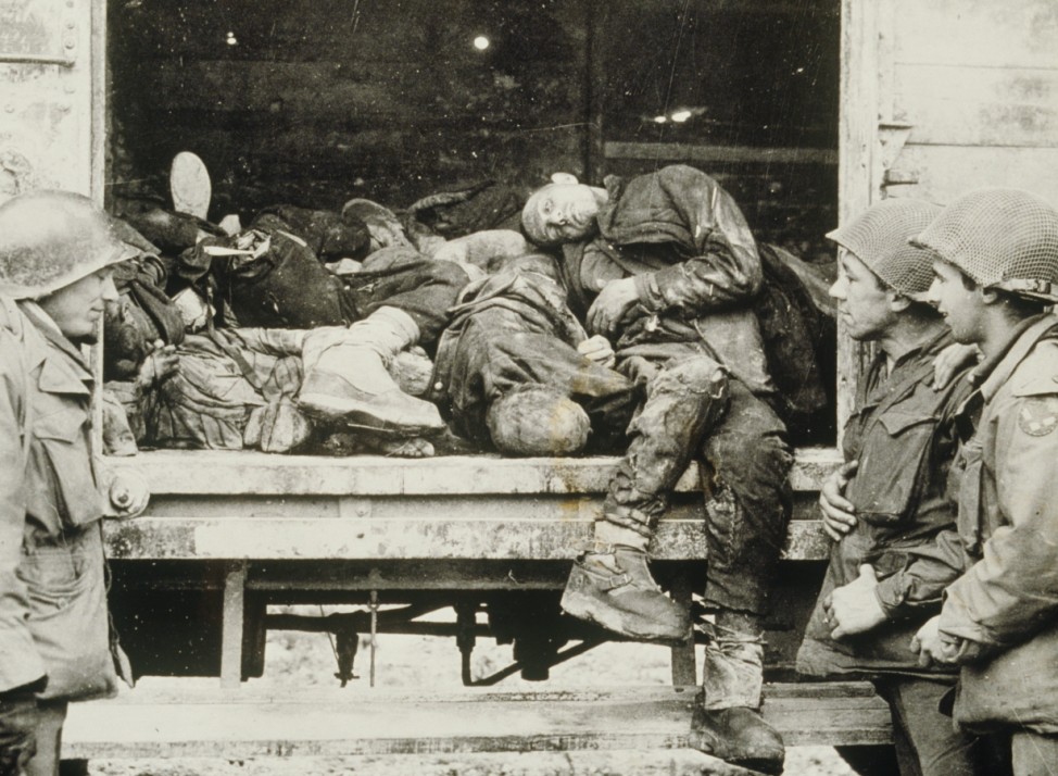 U.S. soldiers in front of a wagon with concentration camp prisoners