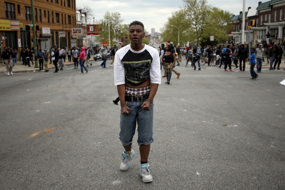 A demonstrator stands on the street after throwing rocks at the Baltimore police during clashes in Baltimore