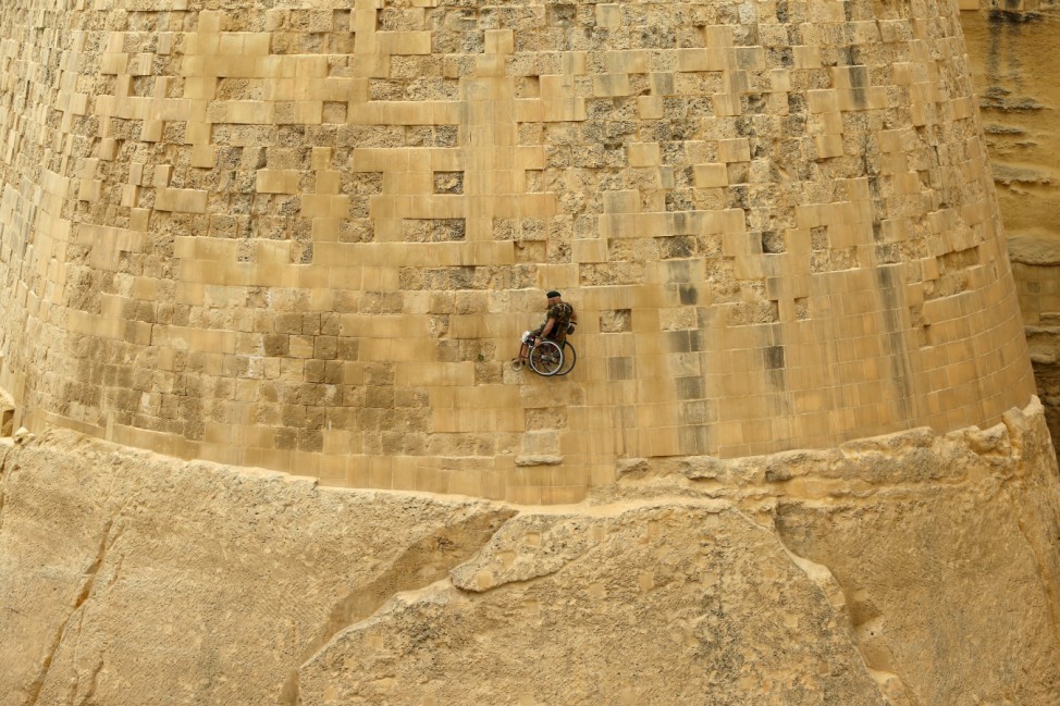 British former police officer Swasie Turner abseils for charity in a wheelchair down the fortification bastions of Valletta, Malta