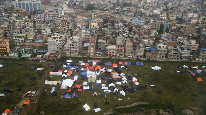 Nepali sleep in provisional tents and under plastic sheets after Saturday's earthquake, near the airport of Kathmandu