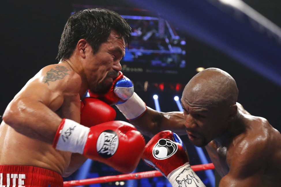Pacquiao of the Philippines takes a punch from Mayweather, Jr. of the U.S. in the fourth round during their welterweight title fight in Las Vegas