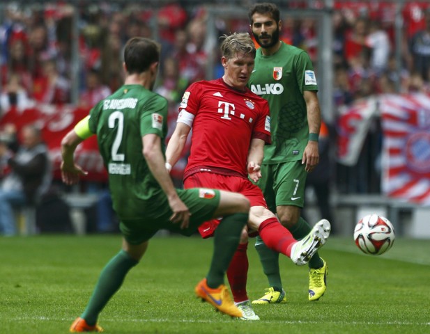 Bayern Munich's Schweinsteiger is tackled by Augsburg's Verhaegh during German Bundesliga first division soccer match in Munich