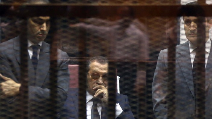 Ägypten: Ägyptens Ex-Präsident Hosni Mubarak (Mitte) und seine Söhne vernehmen die Urteilsverkündung hinter Gittern in einem Gerichtssaal in Kairo.