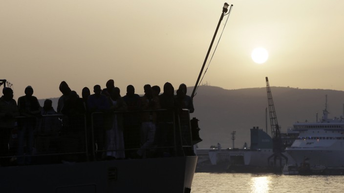 Völkerrecht und Flüchtlingspolitik: Flüchtlingen warten im Hafen von Messina darauf, an Land gehen zu können.