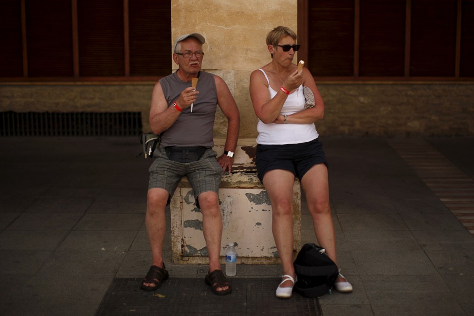 Tourists eat ice cream during a hot spring day in the old city of Ronda